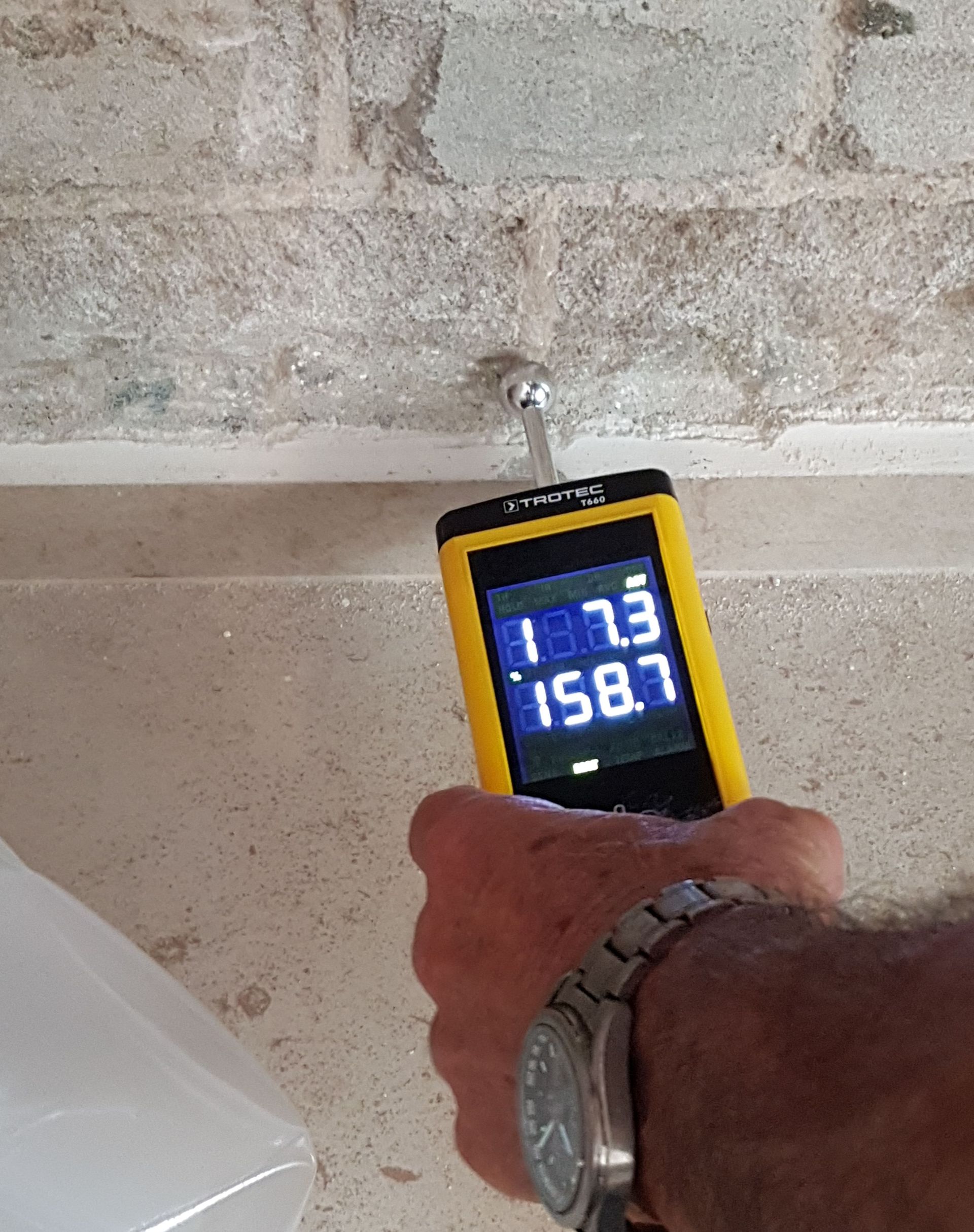 A moisture meter used on a building wall